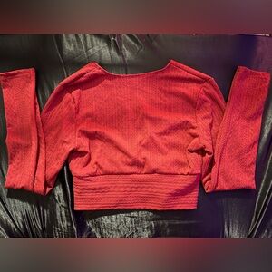 Red, long sleeved cropped blouse.